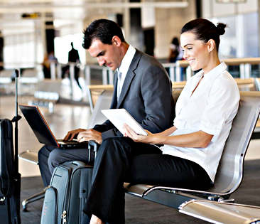 Reise- und Auslandsrechtsschutz: Kollegen sitzen in Flughafen-Wartehalle
